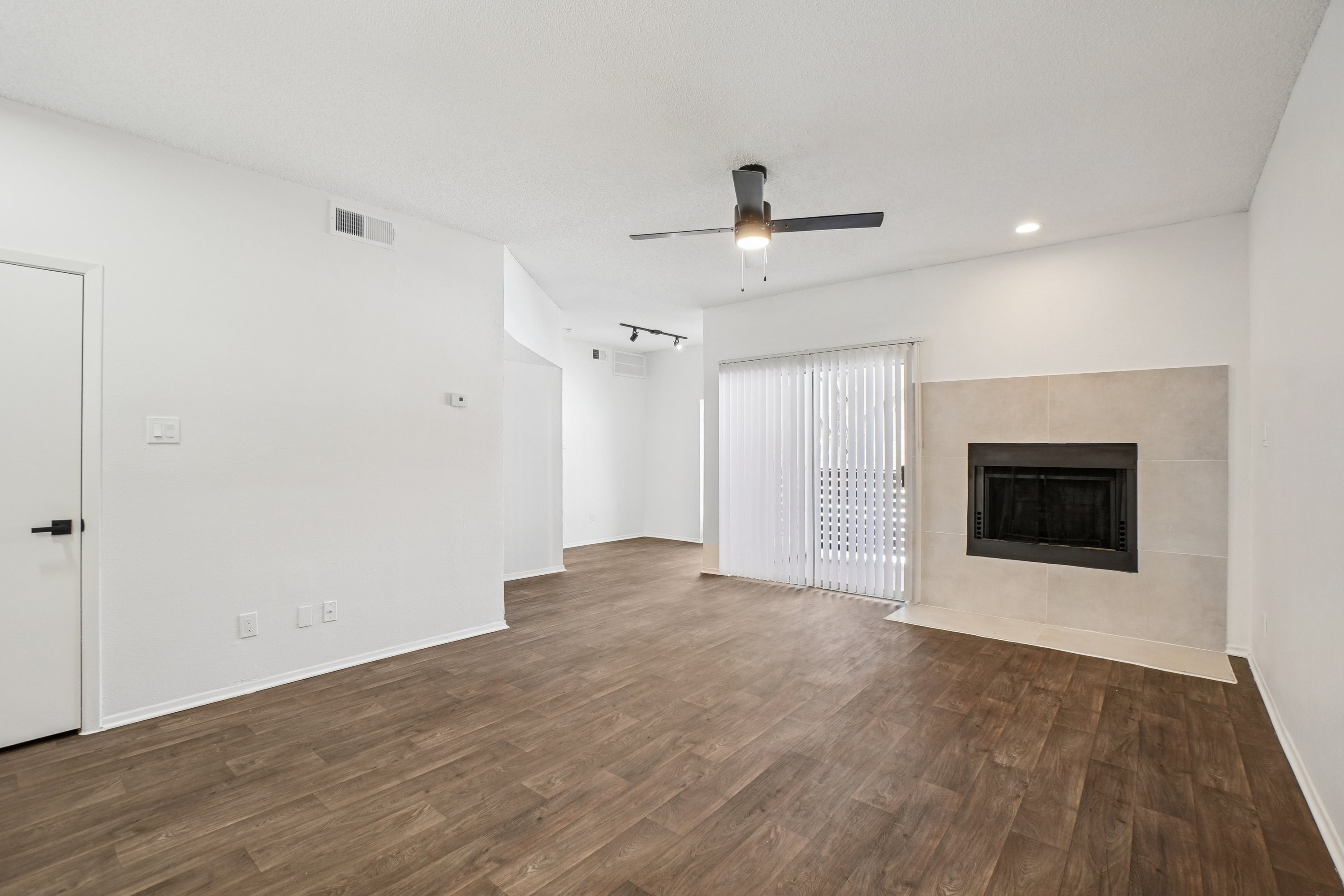 A room with a fireplace and a ceiling fan.